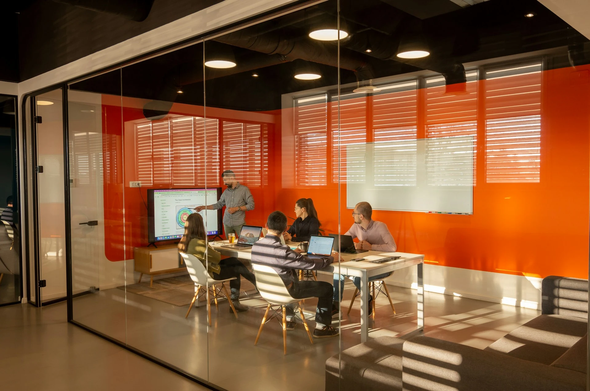 A diverse team in a modern office, gathered around a table for a meeting.