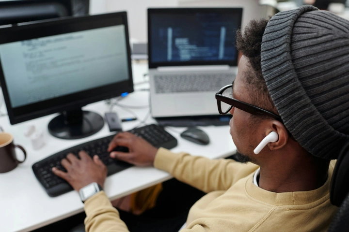 A man transcribing audio on their desktop computer.