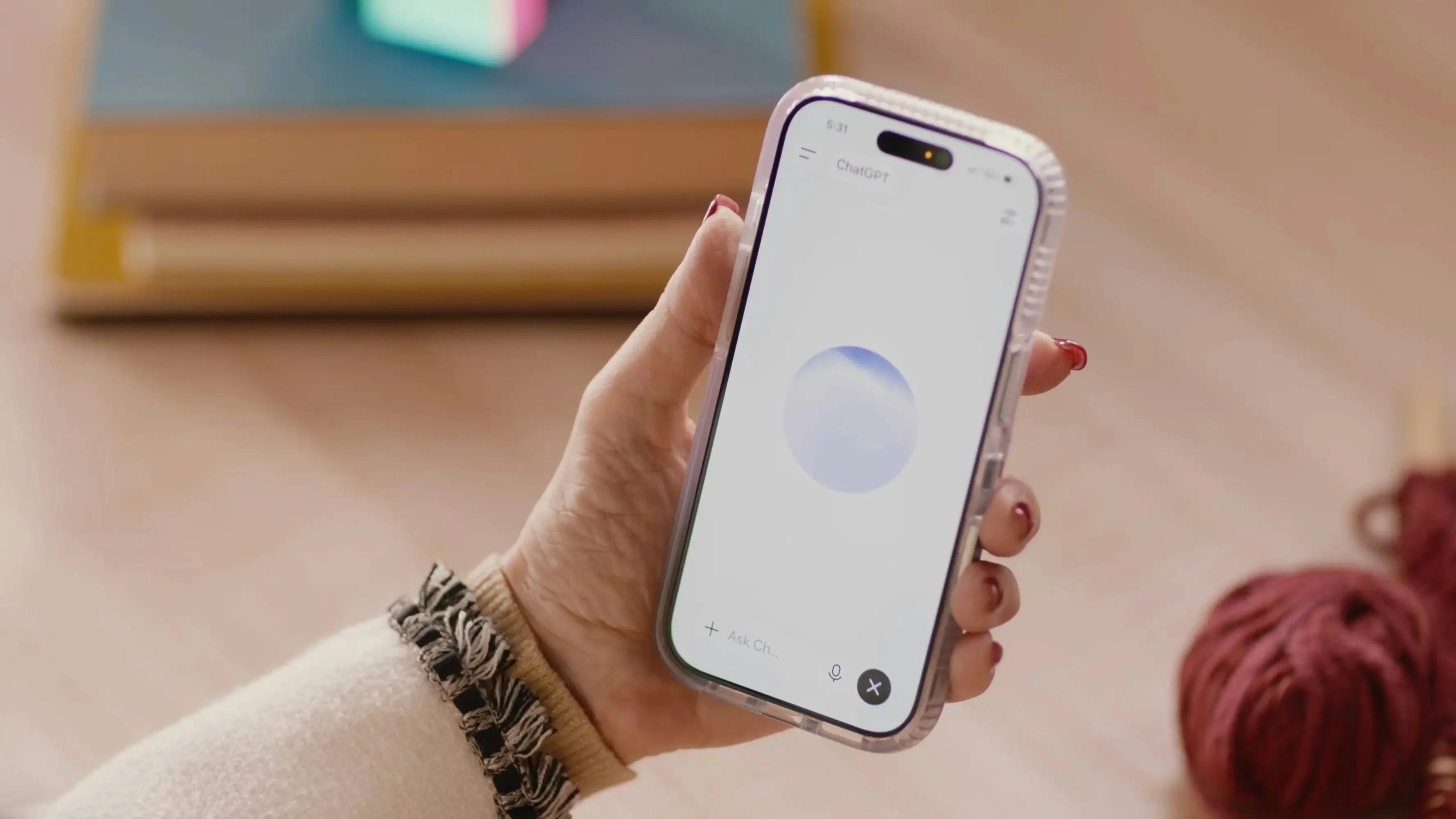 A hand holding a smartphone displaying the ChatGPT Voice Mode interface.