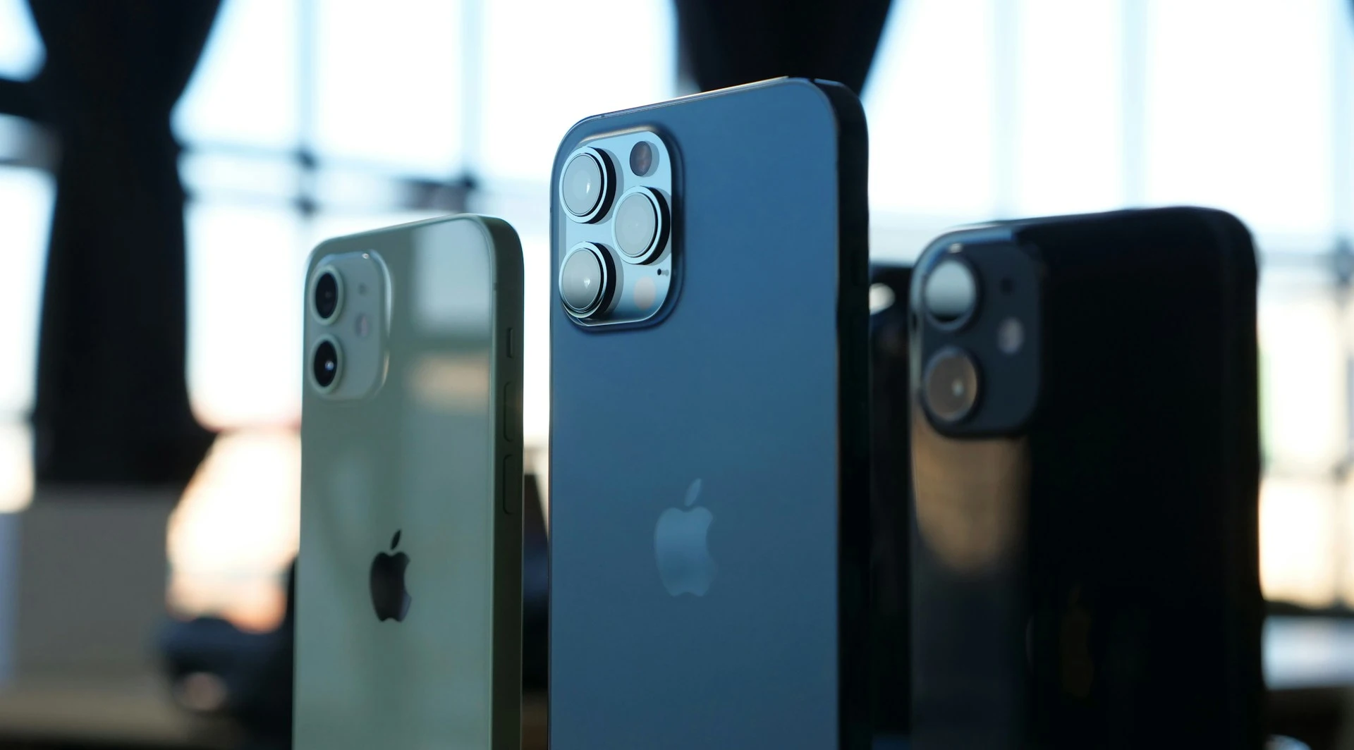  A close-up, side-by-side shot of three different iPhone models.