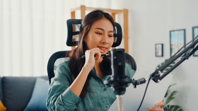 A woman is voice acting in front of a microphone.
