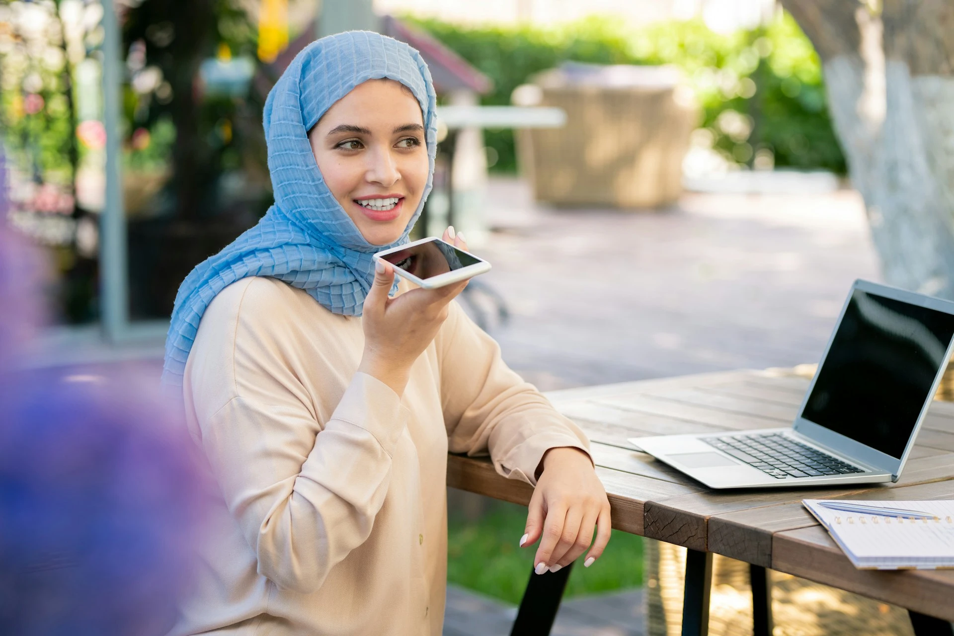  A woman holding her smartphone to her mouth to use a voice dictation feature.