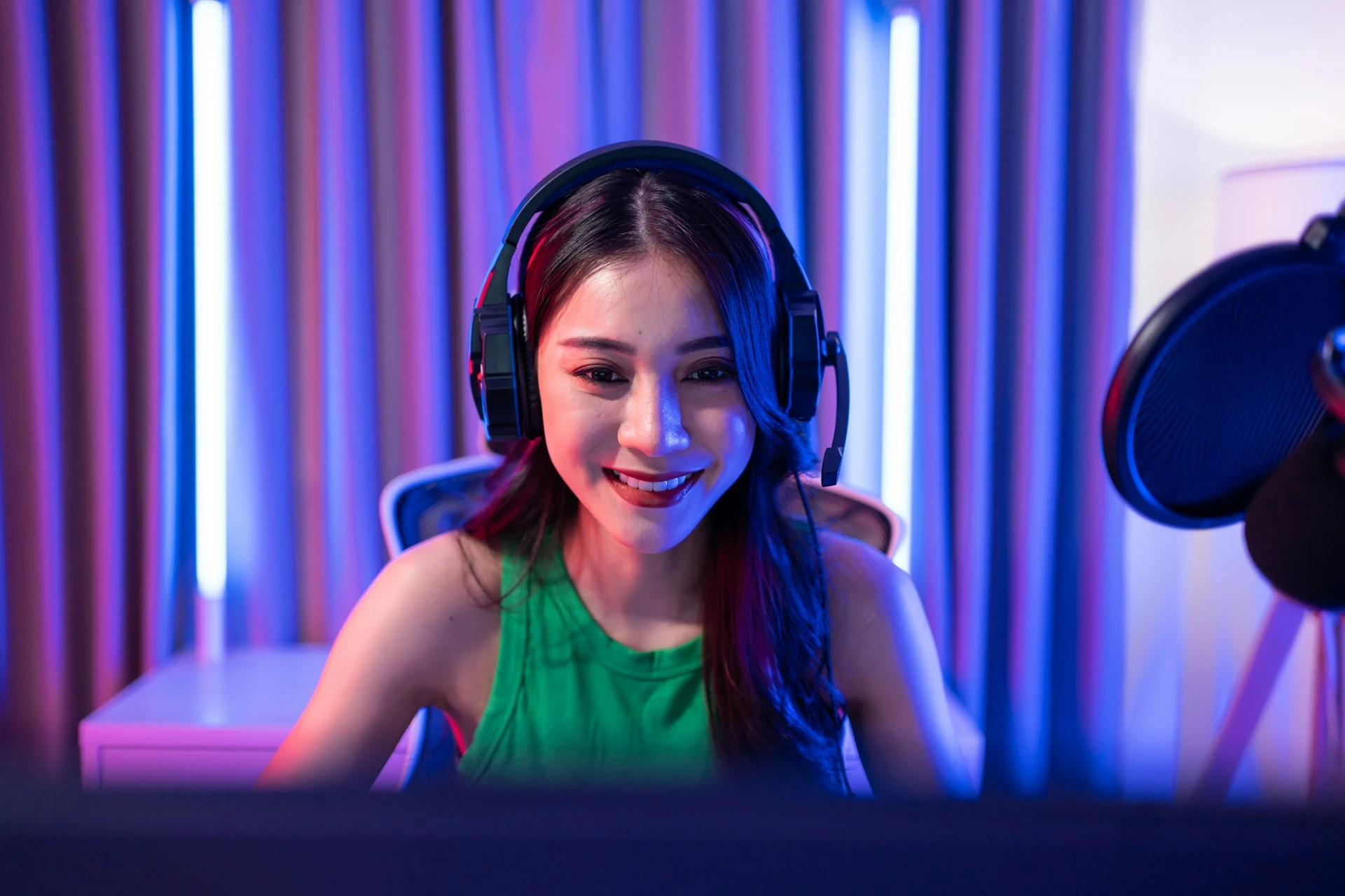 A smiling female streamer wearing headphones.