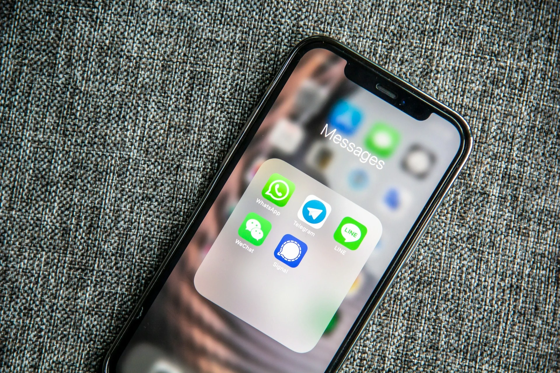  A close-up of an iPhone screen showing a folder of messaging apps.