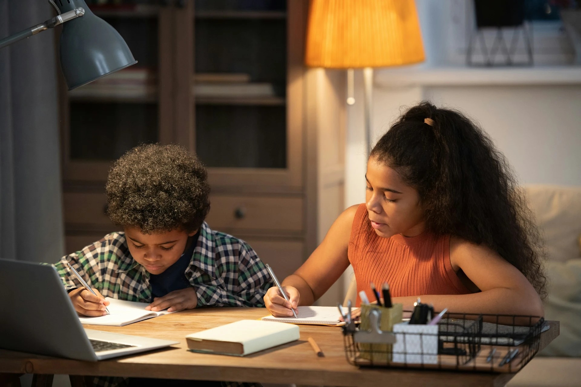 Two children sitting at a desk studying together.