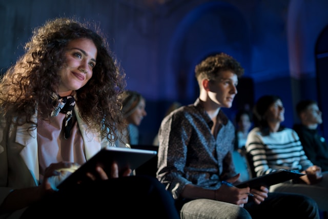 People taking notes during a live event.