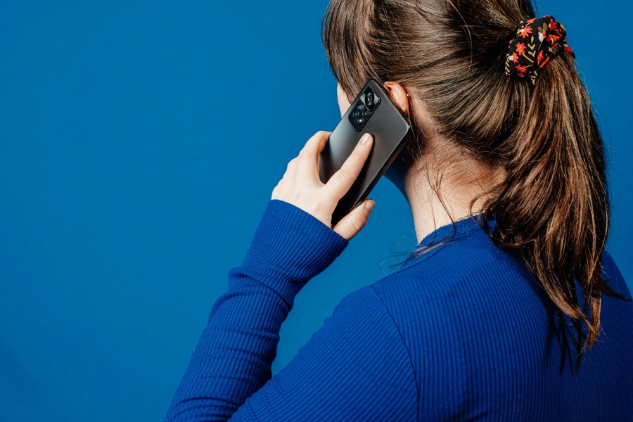 A woman listening to a voice memo on her iPhone