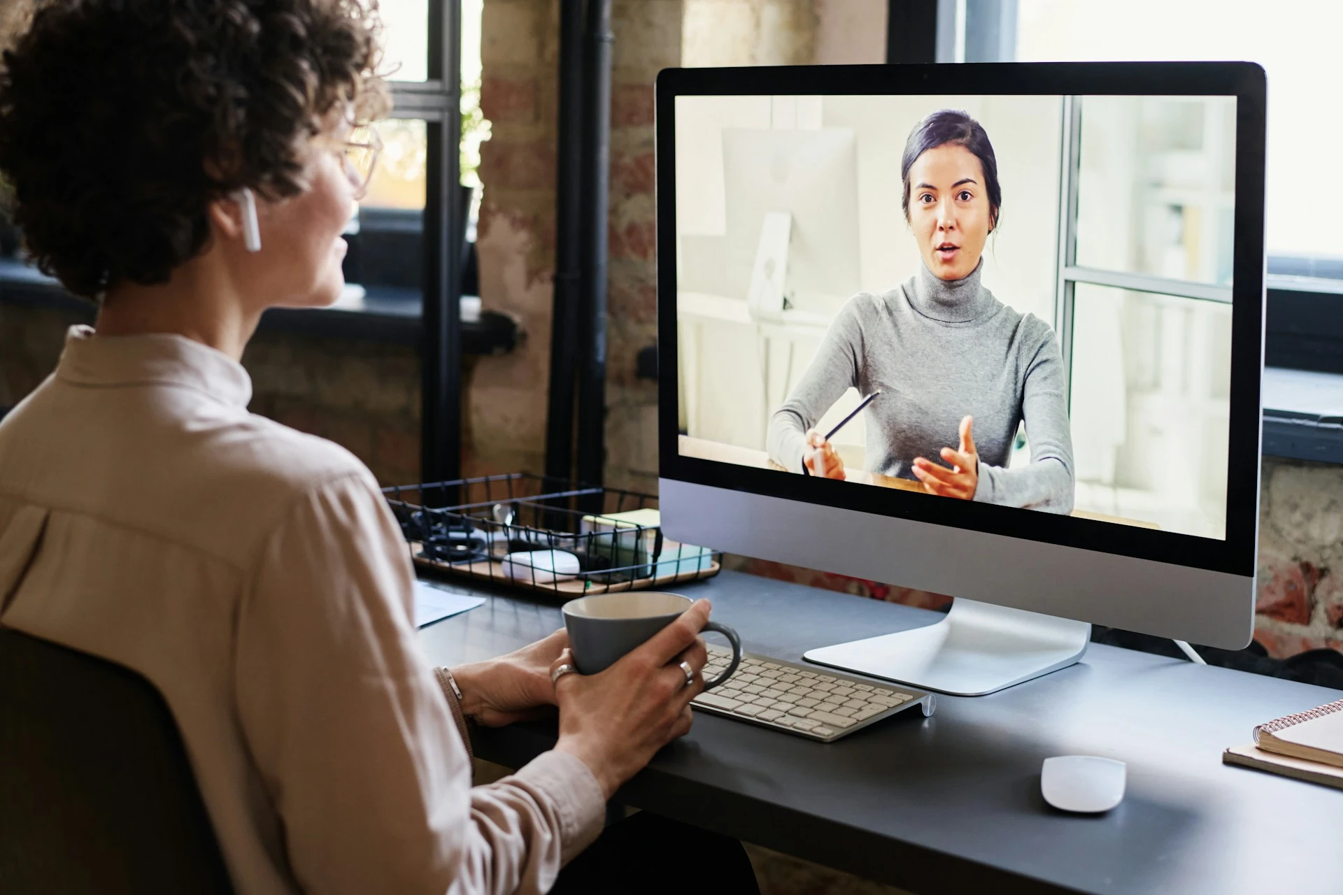 Person attending an online lecture on a computer screen during a video call.