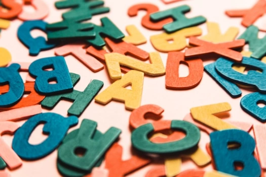 Colorful letters scattered on pink surface.