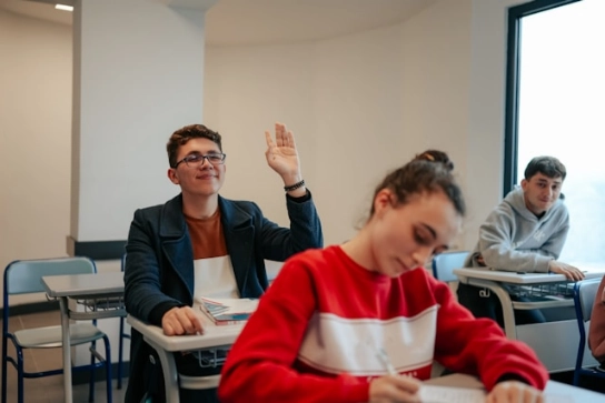 A student raising hand in class.