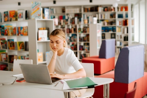 A woman sitting at a desk and using a laptop.