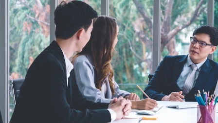 Three people at a business meeting.