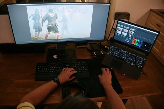 A video editor working on a project with multiple screens.