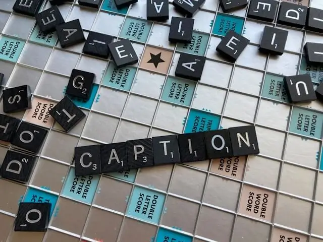 Close-up of the word caption written with scrabble tiles.