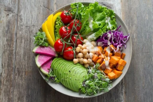 A bowl full of healthy food on wooden surface.