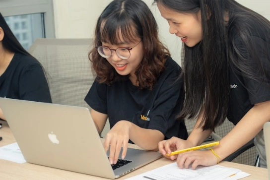 Two students looking at a laptop screen.