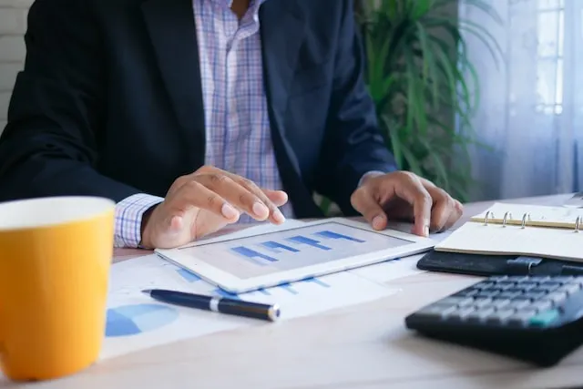 A man looking at a graph from his tablet.