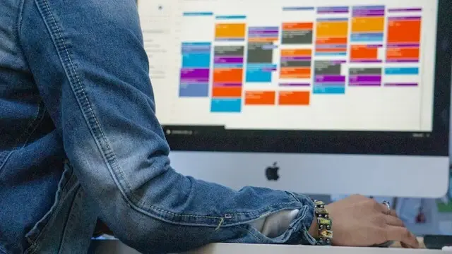 A person using Google Calendar on iMac for scheduling.