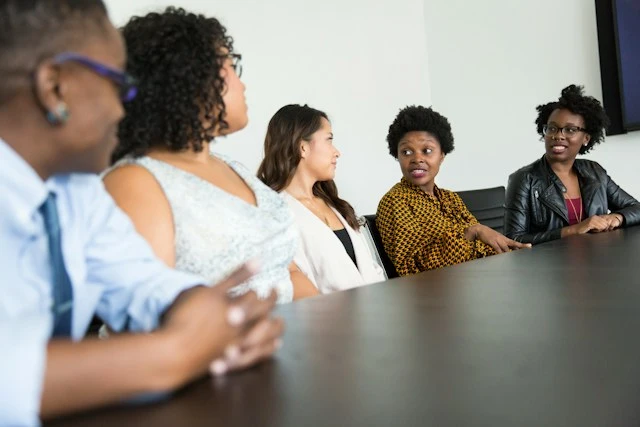 Five people sitting around a table and discussing.