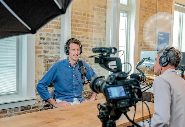 Two men conducting an interview with microphones and headphones.