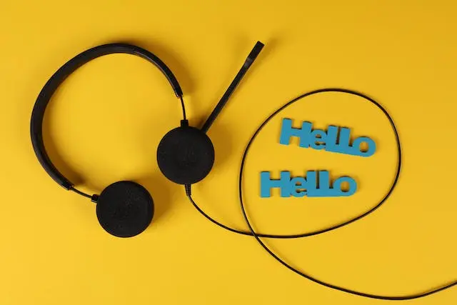 A black headphone and the words of "Hello" on yellow background.