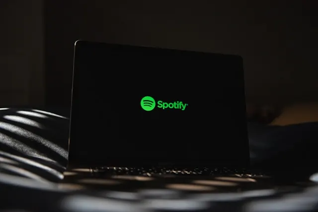 A laptop screen displaying the Spotify logo.