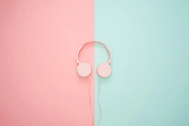 A pink headphone on blue and pink surface.