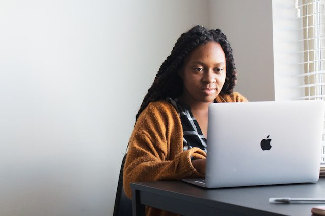 Woman sitting on a chair and using a laptop.