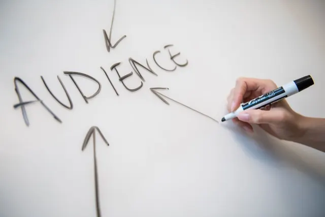 The word "audience" written on a whiteboard with arrows pointing at it.