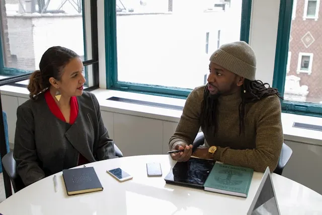 A woman and a man sitting at a table and discussing.