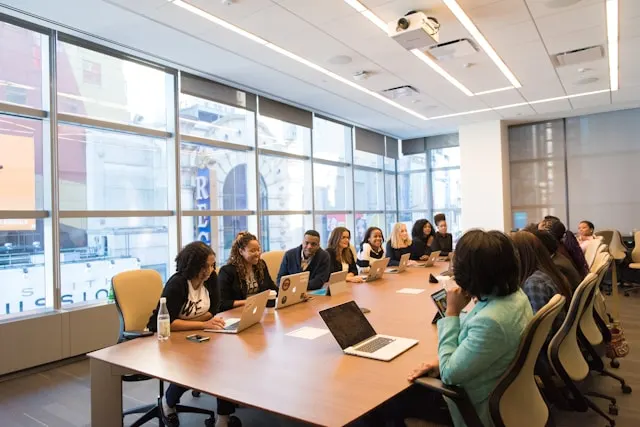 A group of people sitting around a table in an office.