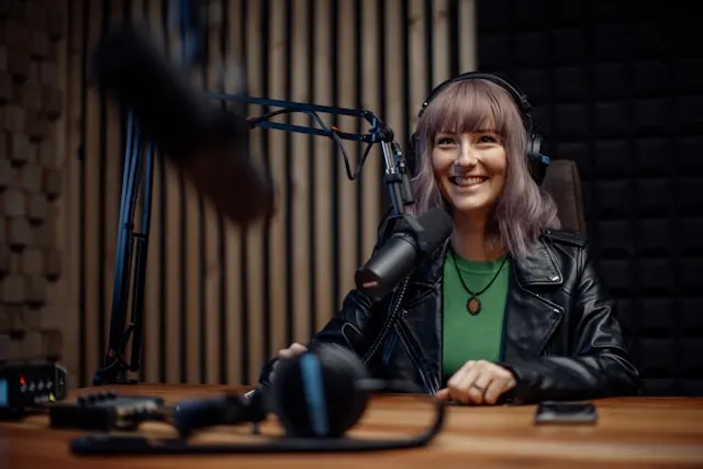 A woman wearing headphones in a podcast studio setup