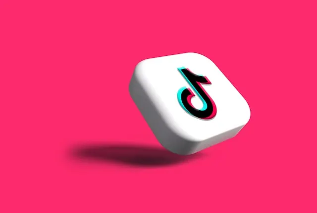 TikTok logo on pink surface.