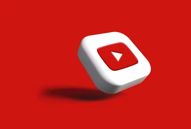 YouTube logo in 3D on red surface.