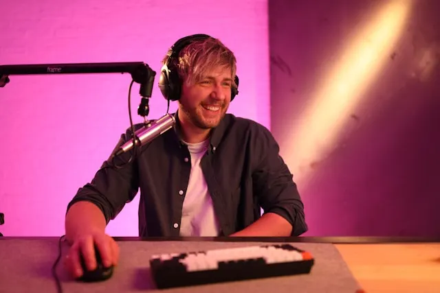 A man wearing headphones and using a mouse.