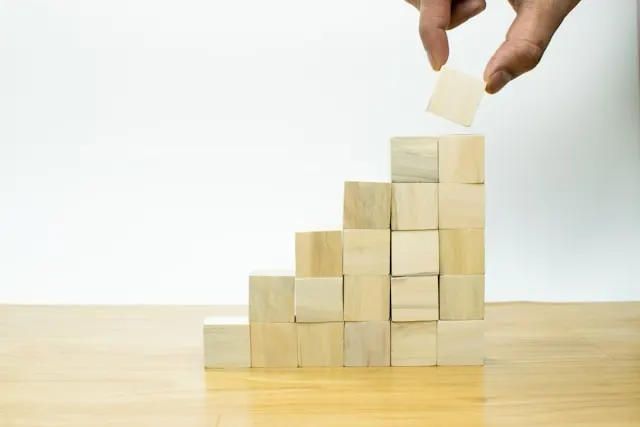 Close-up shot of a hand placing wood cubes on top of each other.