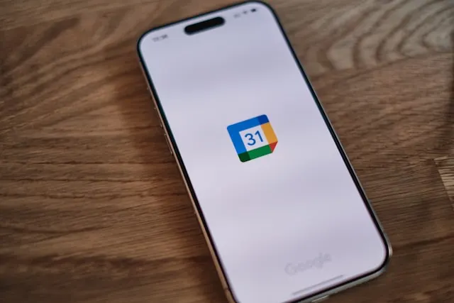 A smartphone screen displaying the Google Calendar logo, one of the best apps to set a meeting cadence