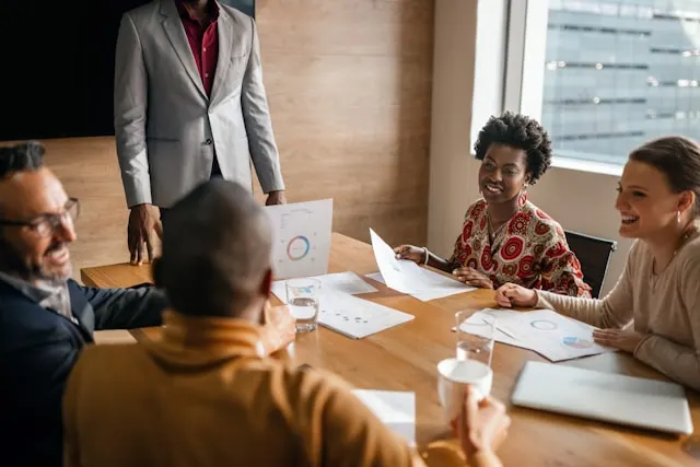 A group of people sitting around a table and looking at data during a quarterly business review meeting.