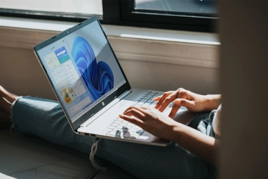 A person using a laptop with Windows 11.