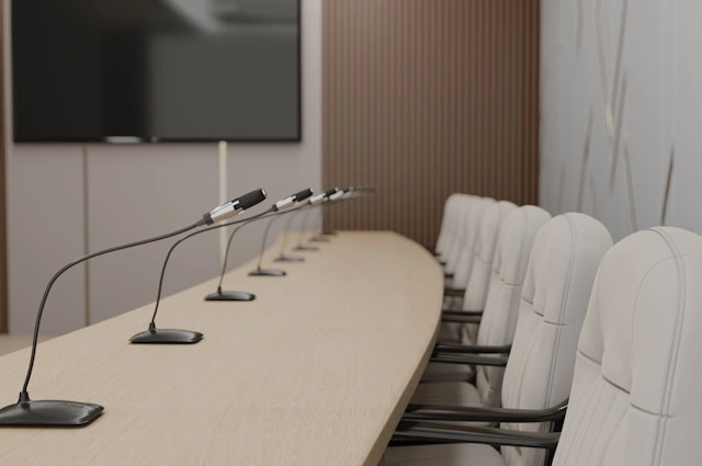 A row of microphones and chairs, one of the hybrid meeting solutions for clear audio.